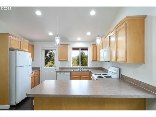 a kitchen with sink refrigerator and window