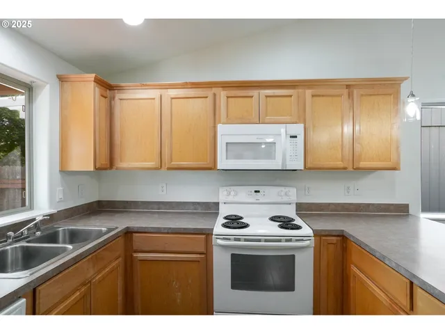 a kitchen with granite countertop a sink and a stove