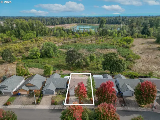 an aerial view of a house with a yard and lake view