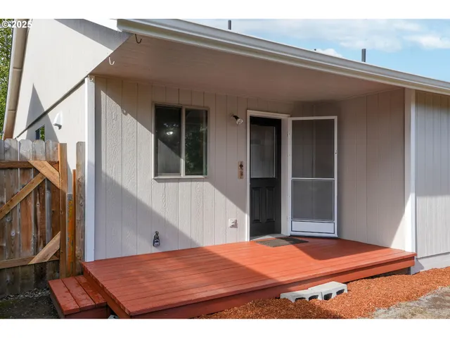 a backyard of a house with table and chairs