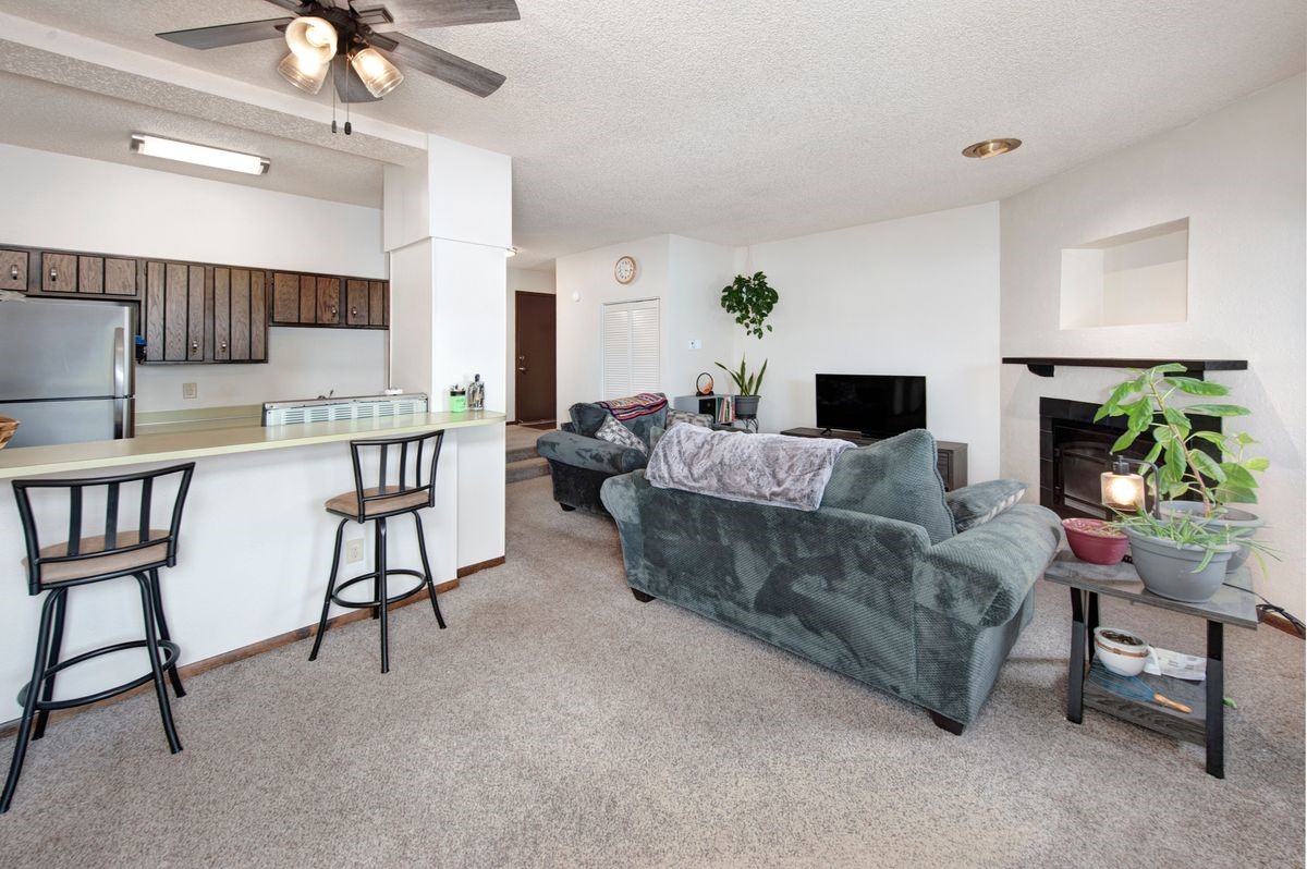 58 Summit Drive, Unit D9 Dillon, CO 80435 - Photo 21 of 34 Living room with a tile fireplace, ceiling fan, a textured ceiling, and light colored carpet