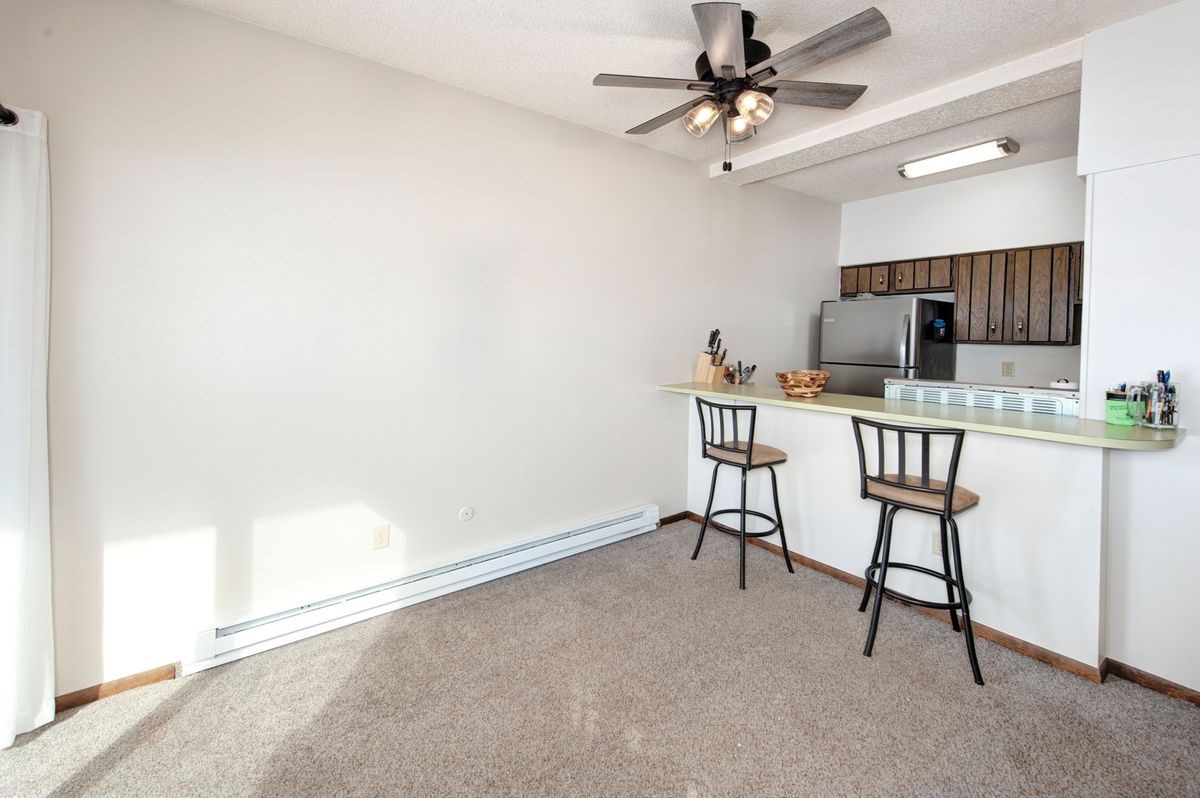 58 Summit Drive, Unit D9 Dillon, CO 80435 - Photo 24 of 34 Kitchen featuring a baseboard radiator, freestanding refrigerator, light colored carpet, light countertops, and a ceiling fan