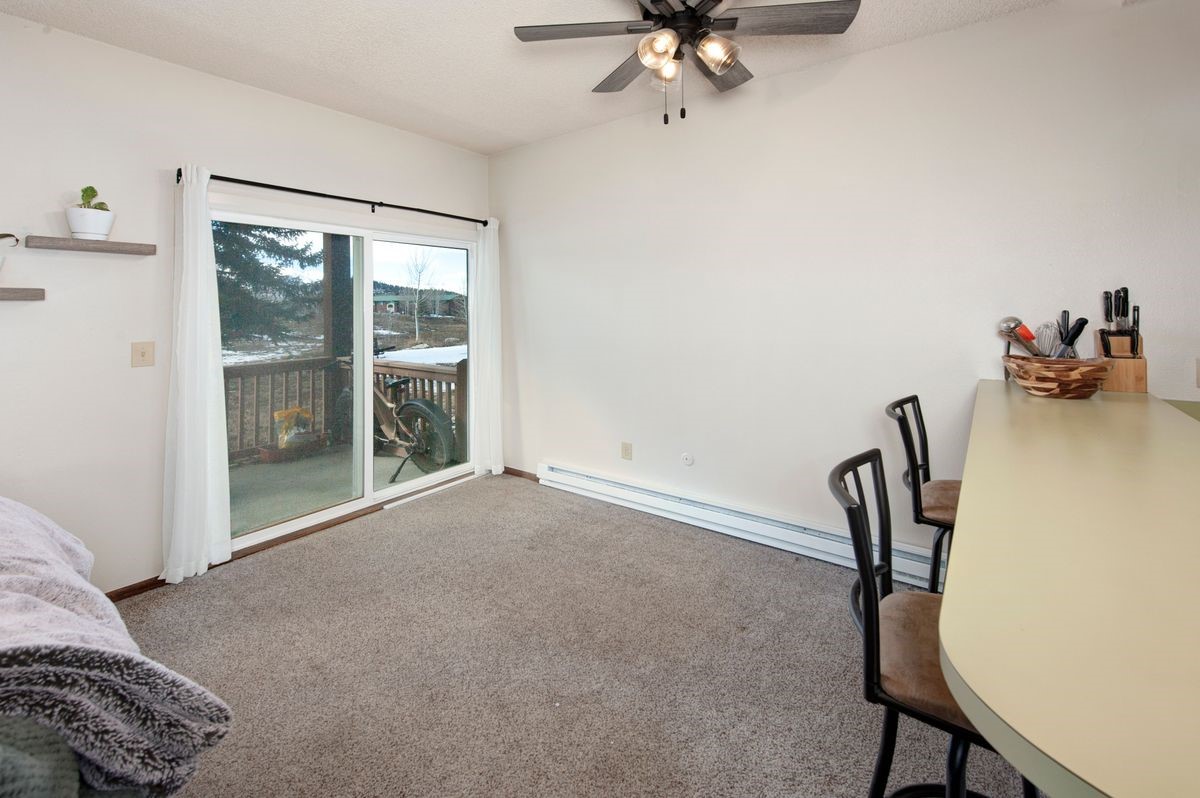58 Summit Drive, Unit D9 Dillon, CO 80435 - Photo 25 of 34 Carpeted dining area with a baseboard heating unit, access to exterior, and ceiling fan