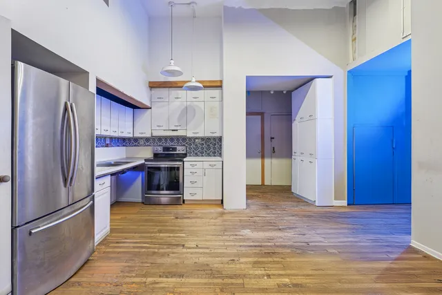 a view of a kitchen with a sink and a refrigerator