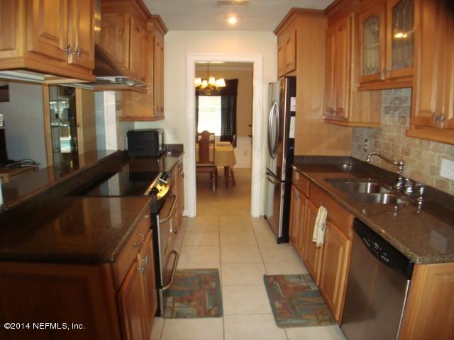 3980 Heidi Road West Jacksonville, FL 32277 - Photo 19 of 46 a kitchen with granite countertop a stove a sink and a refrigerator