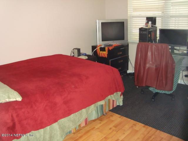 3980 Heidi Road West Jacksonville, FL 32277 - Photo 27 of 46 a bedroom with a bed and a flat screen tv