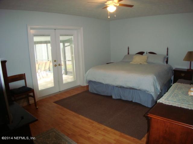3980 Heidi Road West Jacksonville, FL 32277 - Photo 31 of 46 a bedroom with a bed and a chandelier