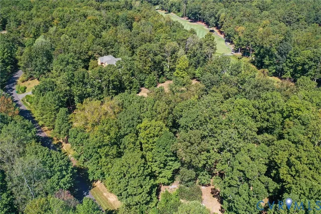 an aerial view of residential house with outdoor space and trees all around