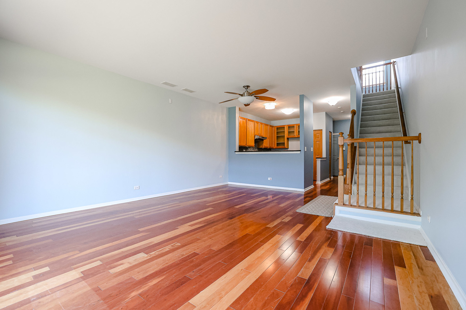2439 Oneida Lane Naperville, IL 60563 - Photo 11 of 25 a view of a room with wooden floor staircase and a kitchen space