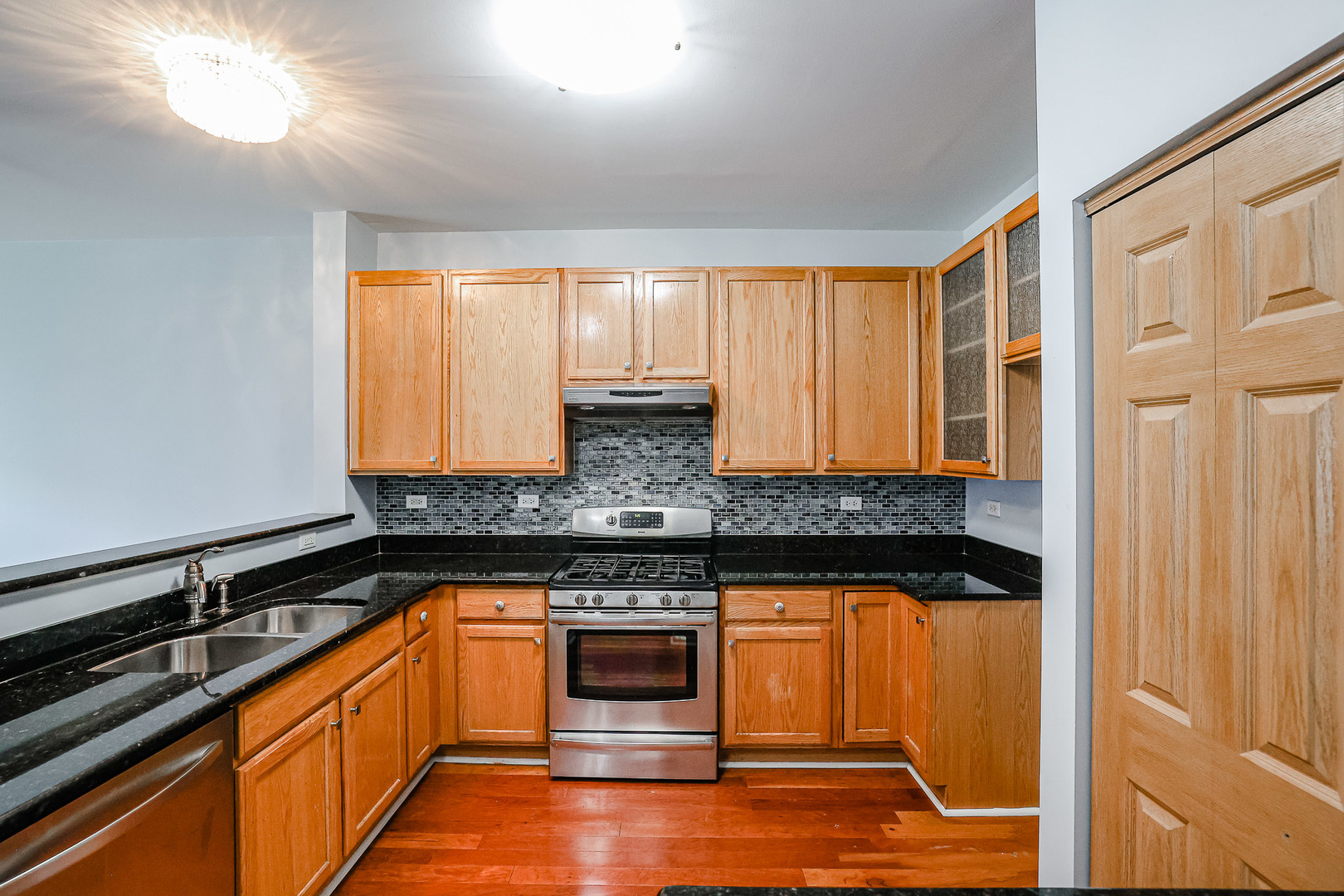 2439 Oneida Lane Naperville, IL 60563 - Photo 2 of 25 a kitchen with granite countertop wooden cabinets and a wooden floor