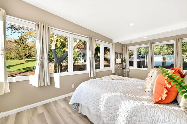 a view of a hallway with wooden floor and windows