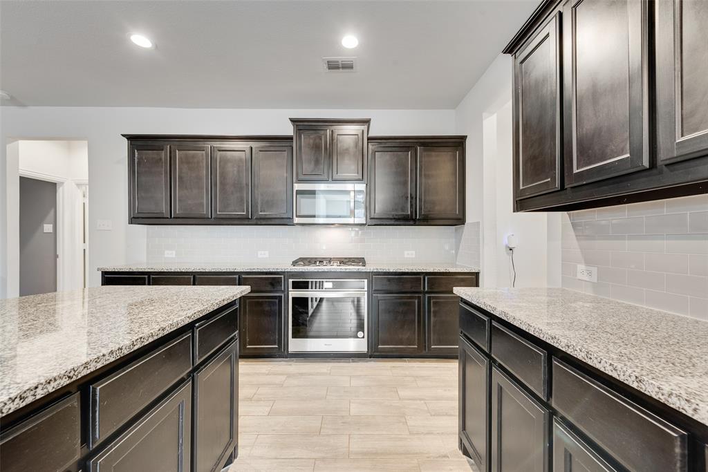 1279 Altuda Drive Forney, TX 75126 - Photo 14 of 35 a kitchen with stainless steel appliances granite countertop a sink stove and refrigerator