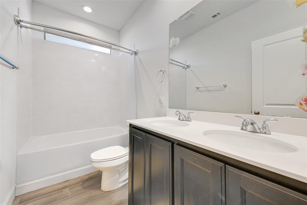 1279 Altuda Drive Forney, TX 75126 - Photo 17 of 35 a bathroom with a sink a toilet and a large mirror