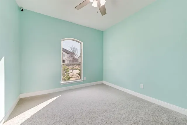 an empty room with a window and a fan
