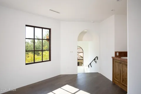 an empty room with windows and fireplace