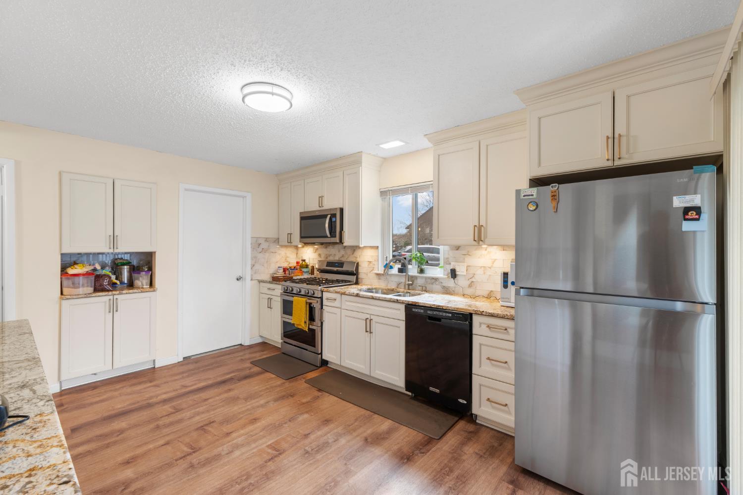 272 Westgate Drive Edison, NJ 08820 - Photo 20 of 47 a kitchen with stainless steel appliances granite countertop a refrigerator stove a sink and dishwasher with wooden floor