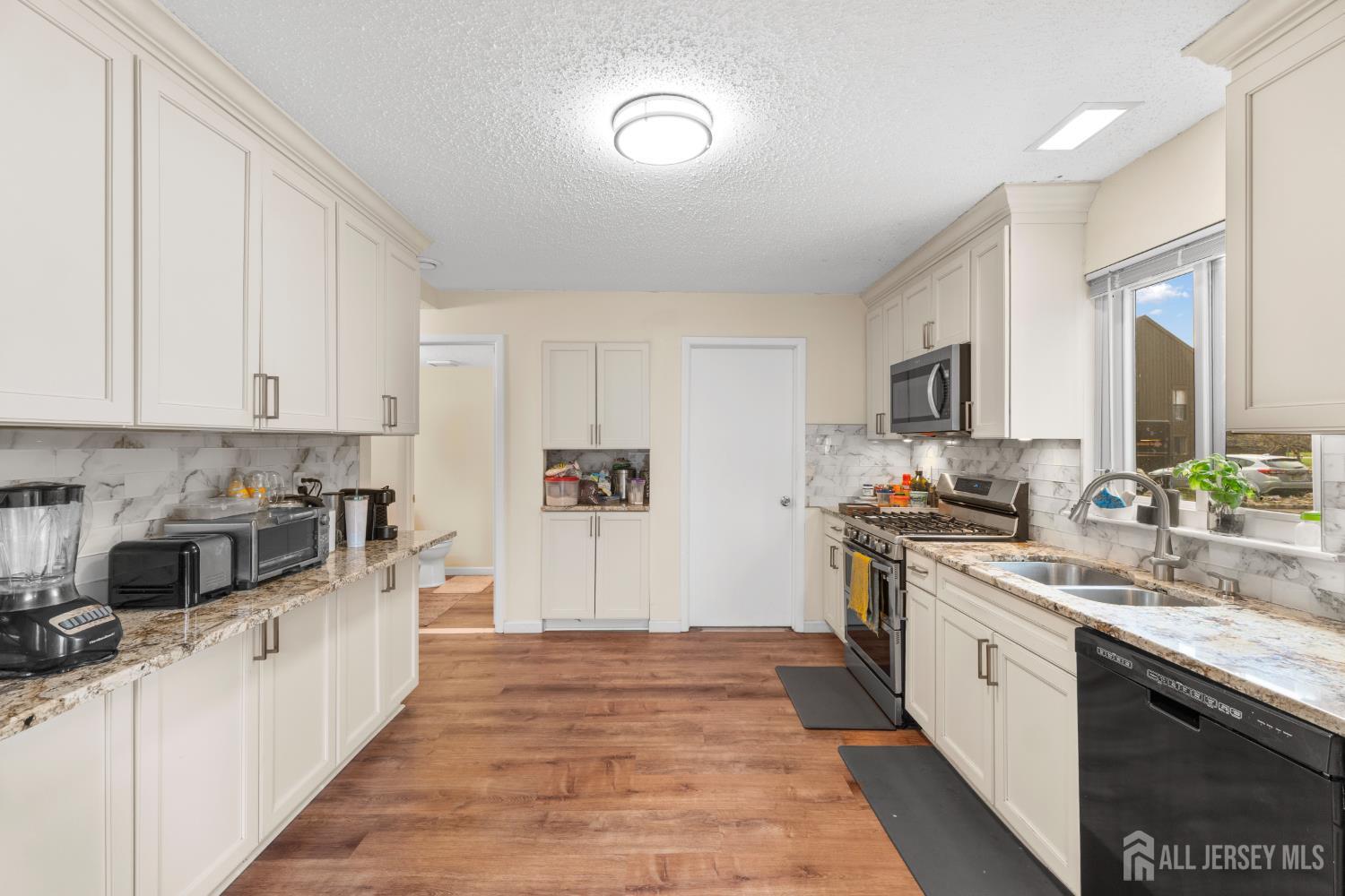 272 Westgate Drive Edison, NJ 08820 - Photo 23 of 47 a large white kitchen with stainless steel appliances granite countertop a stove a sink dishwasher and a refrigerator