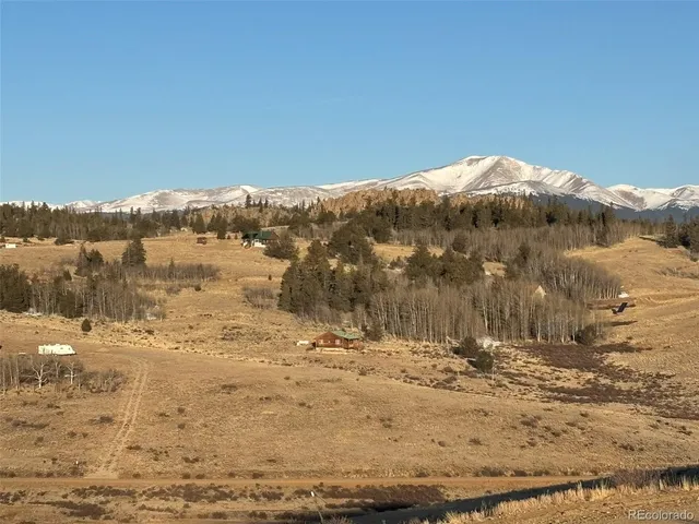 a view of a large building with mountains in the background