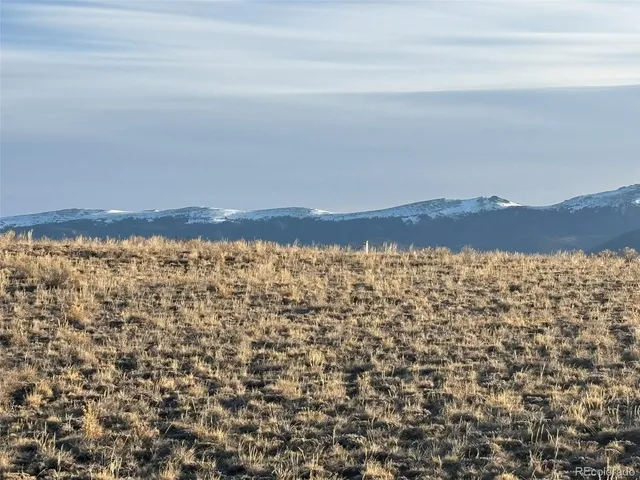 an aerial view of house with yard and mountain in the background