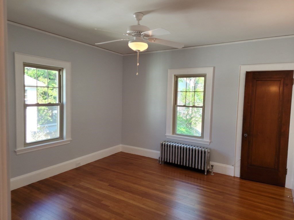 133 Fairview Avenue, Unit 133 Belmont, MA 02478 - Photo 19 of 33 an empty room with wooden floor and windows