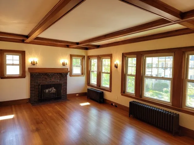 a living room with a fireplace and wooden floor