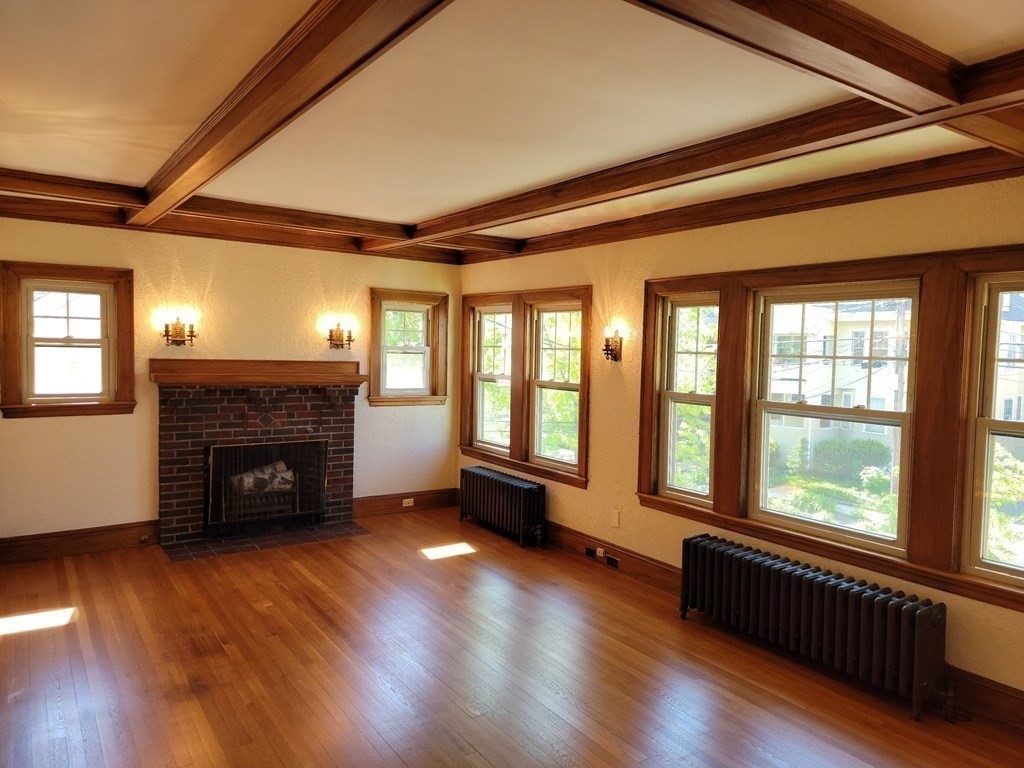 133 Fairview Avenue, Unit 133 Belmont, MA 02478 - Photo 2 of 33 a living room with a fireplace and wooden floor