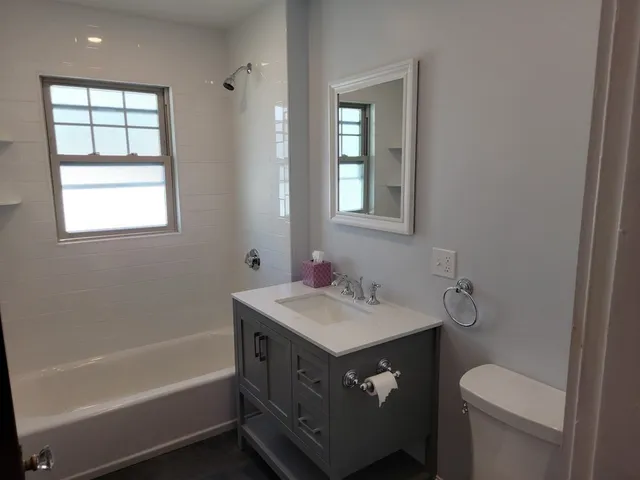 a bathroom with a sink toilet vanity and bathtub