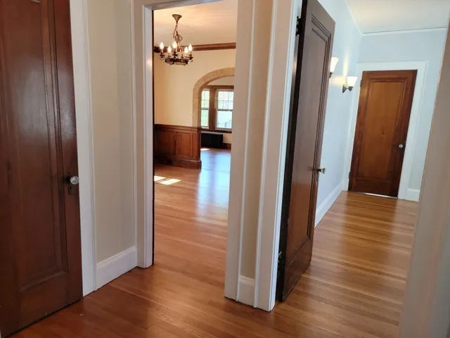 a view of a hallway with wooden floor and staircase