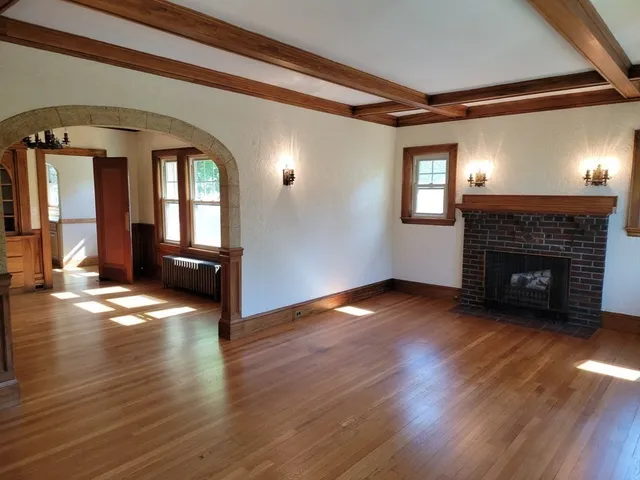 a view of empty room with wooden floor and fireplace