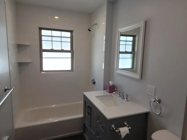 a bathroom with a sink vanity tub and a mirror