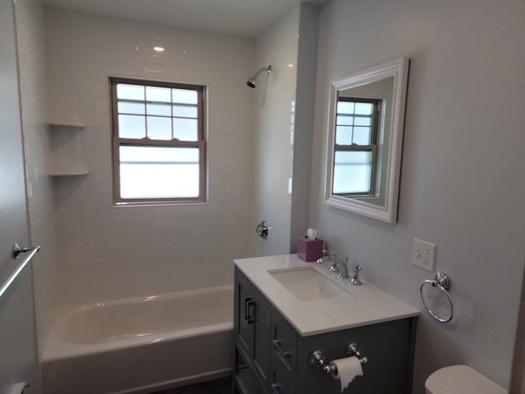 133 Fairview Avenue, Unit 133 Belmont, MA 02478 - Photo 5 of 33 a bathroom with a sink vanity tub and a mirror