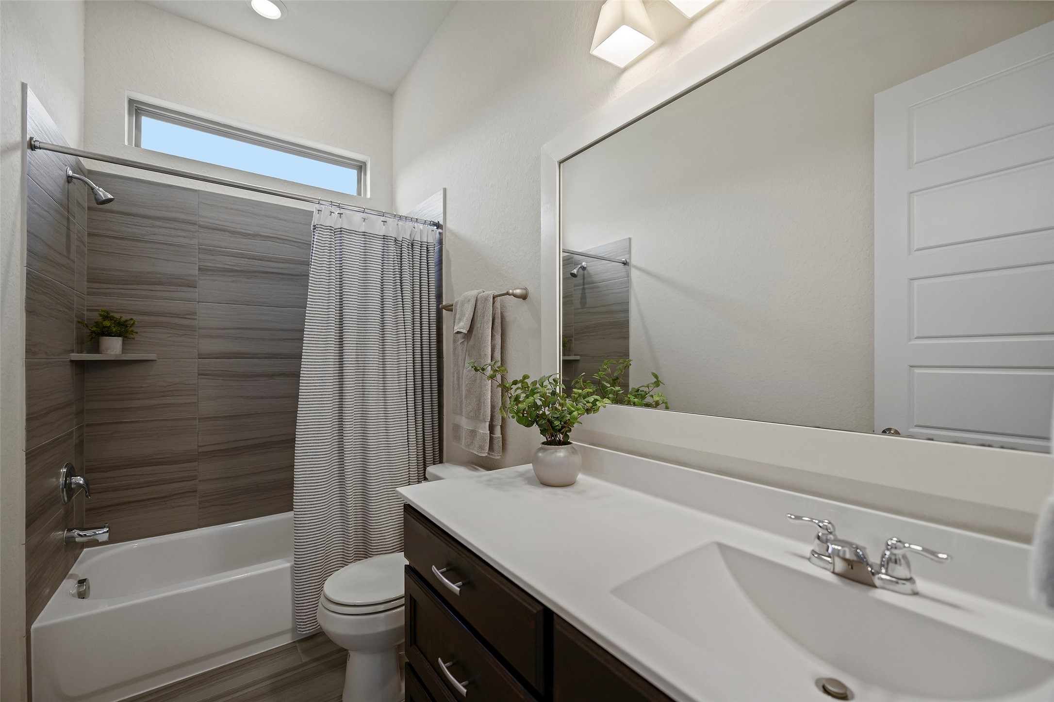 20330 Rosegold Way Spring, TX 77379 - Photo 40 of 48 Secondary bathroom with quartz countertops, oversized mirror, and stylish tile surround.