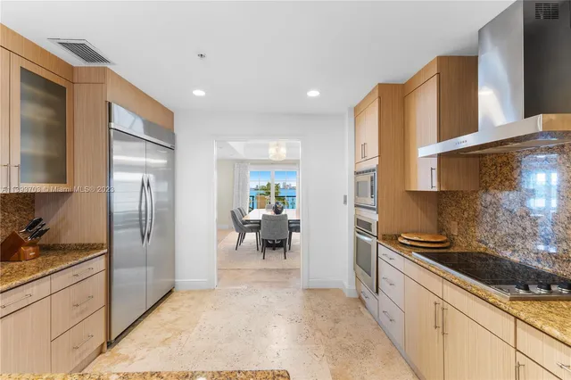 a kitchen with stainless steel appliances granite countertop a refrigerator and a sink