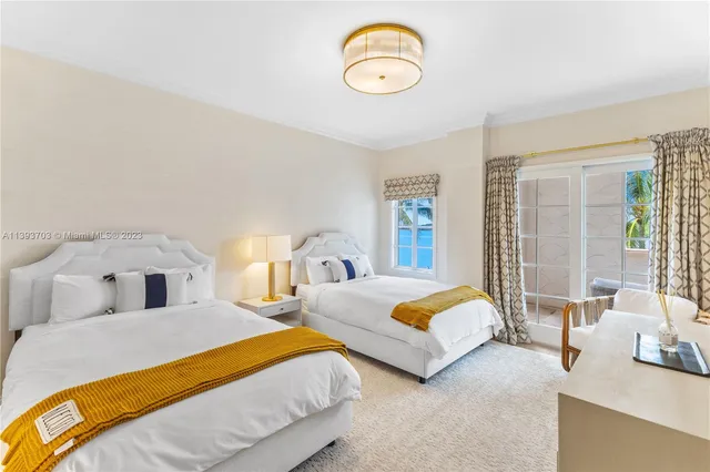 a bedroom with two beds and a large window