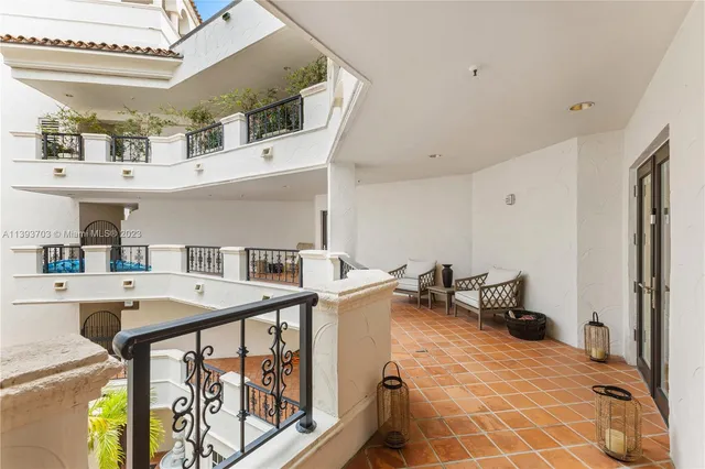 a view of a patio with couches table and chairs under an umbrella