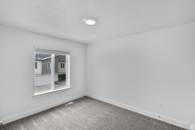3014 South 265th Street West Logan, UT 84321 - Photo 11 of 25 Neutral white walls, plush gray carpeting, and a white-trimmed window with roller blinds