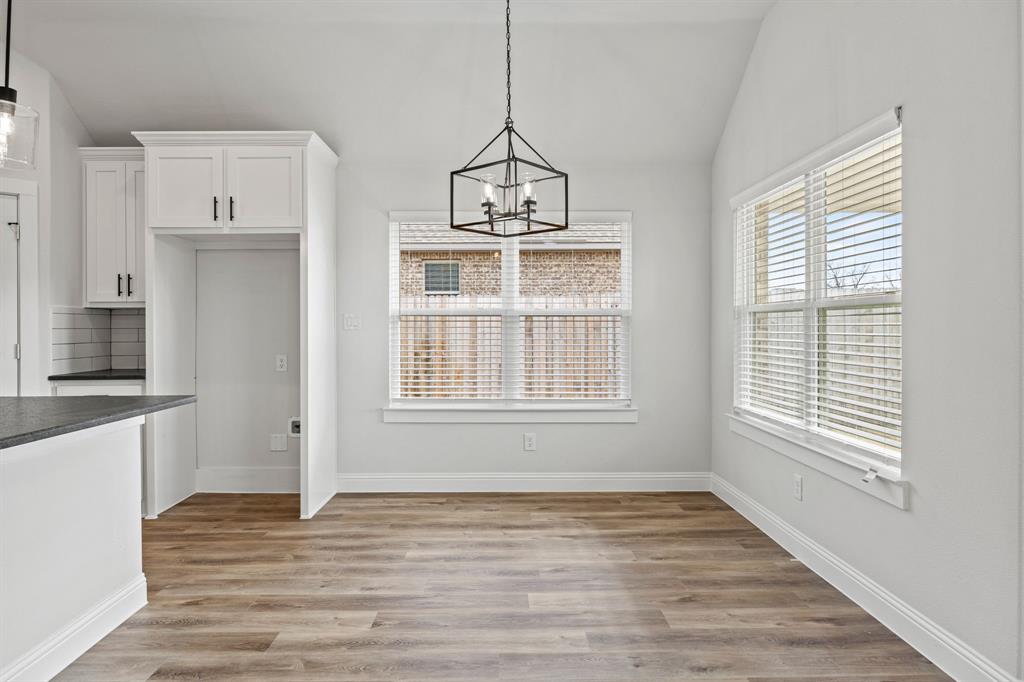 102 Maverick Trail Valley View, TX 76272 - Photo 6 of 32 a view of an empty room with wooden floor and a window