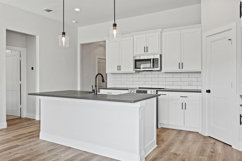 102 Maverick Trail Valley View, TX 76272 - Photo 9 of 32 a kitchen with stainless steel appliances granite countertop a sink and microwave