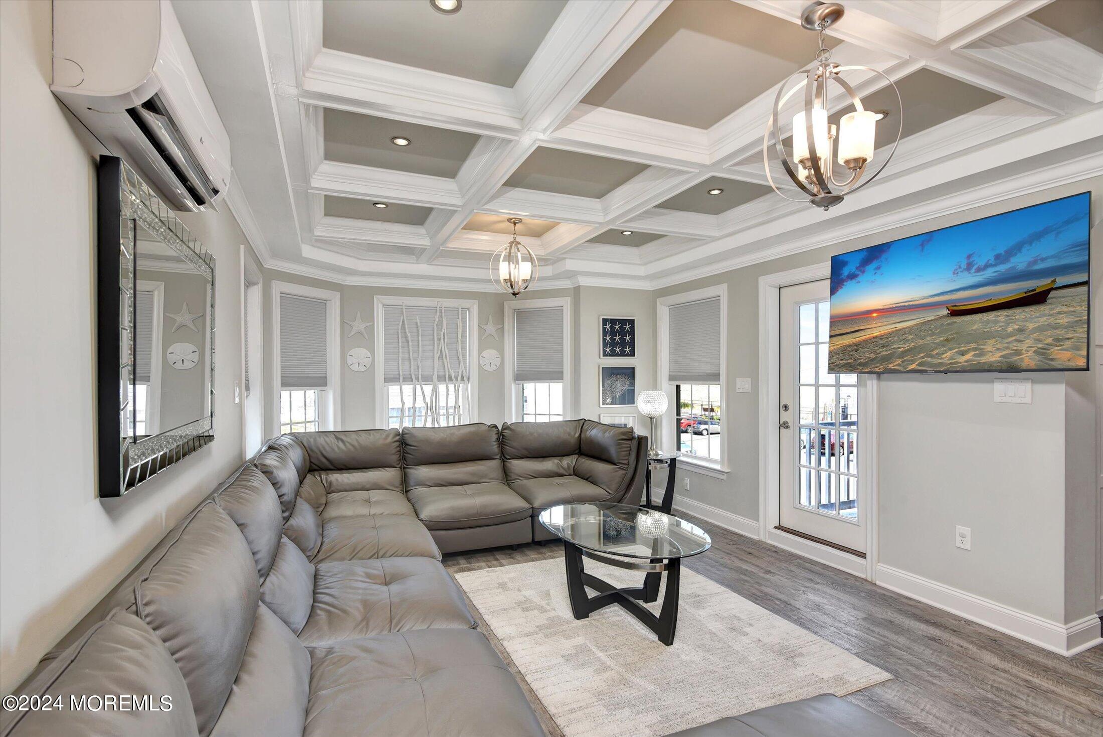 5 Fielder Avenue Seaside Heights, NJ 08751 - Photo 22 of 55 a living room with furniture a chandelier and a dining table with wooden floors