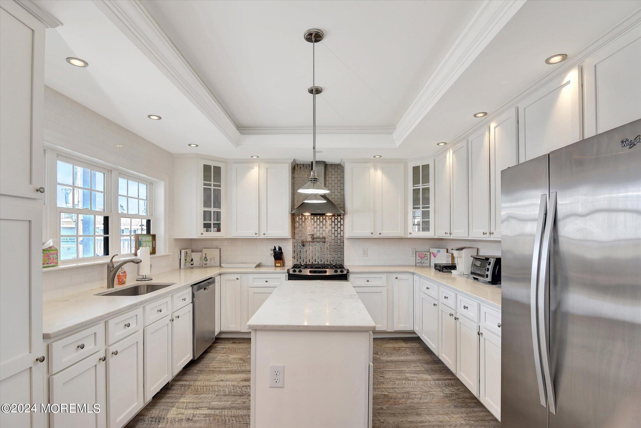 5 Fielder Avenue Seaside Heights, NJ 08751 - Photo 23 of 55 a kitchen with a refrigerator a sink dishwasher a stove and white cabinets with wooden floor