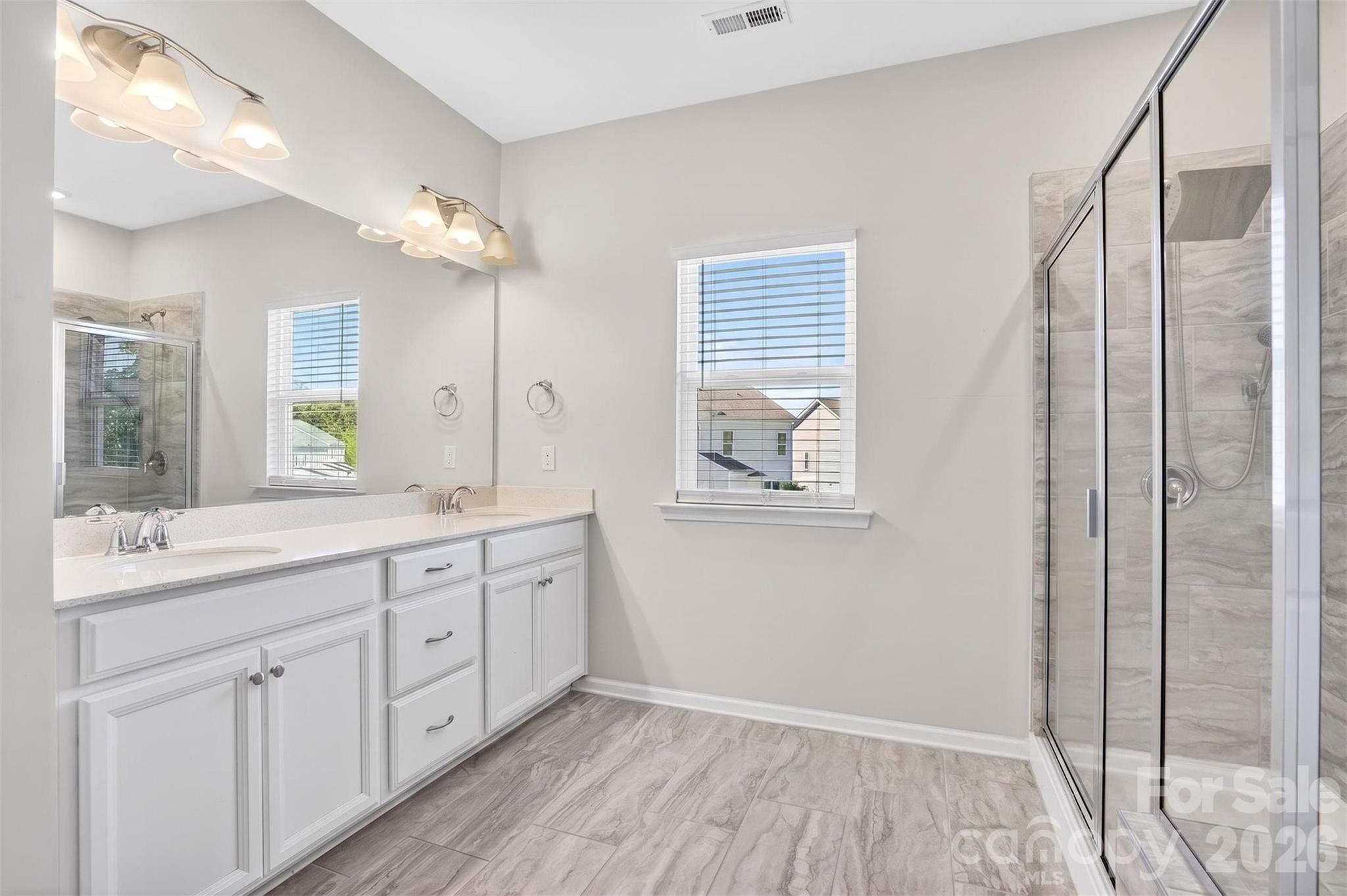 764 River Park Road Belmont, NC 28012 - Photo 22 of 27 a bathroom with a double vanity sink and mirror with shower