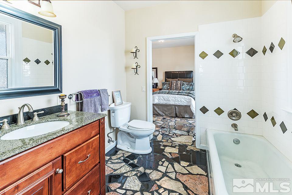 635 South Arlington Avenue Reno, NV 89509 - Photo 12 of 25 a bathroom with a granite countertop sink mirror vanity and toilet