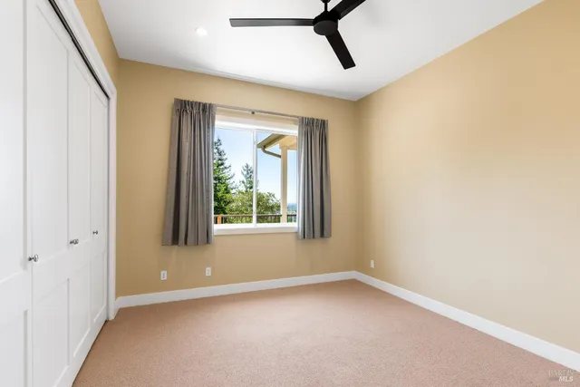 a view of a livingroom with a window and a ceiling fan