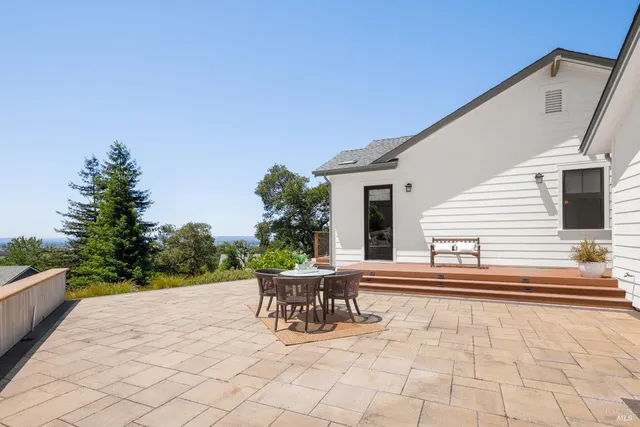 a patio with table and chairs and potted plants