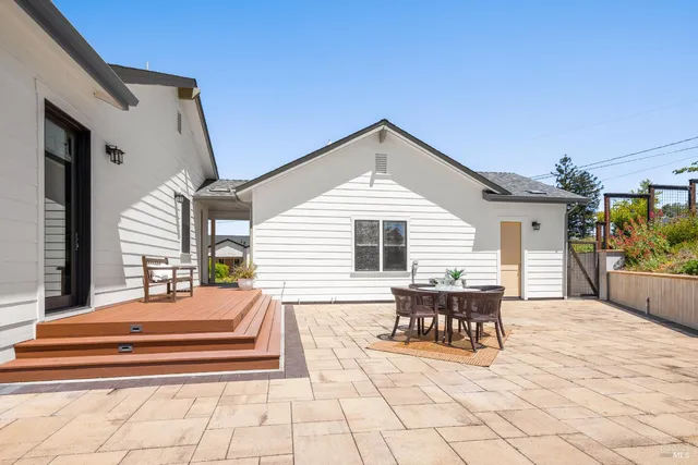 a view of a patio with dining table and chairs with wooden floor