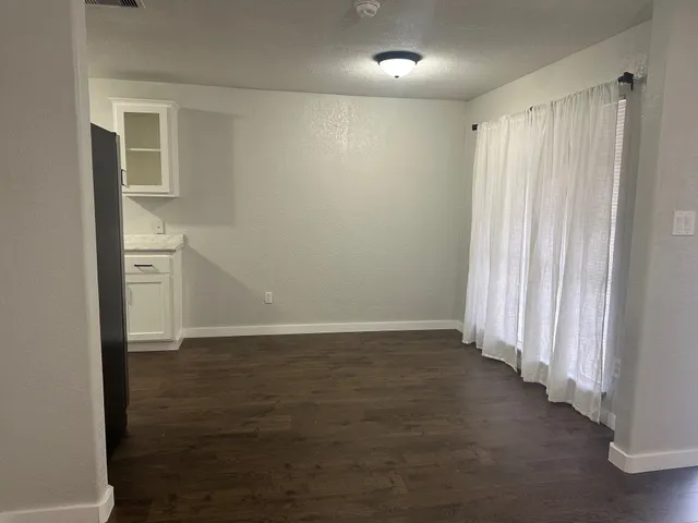 an empty room with wooden floor and a window