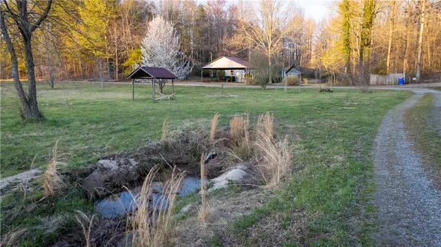 a view of a yard with wooden fence