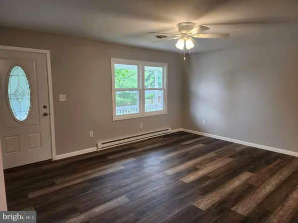 wooden floor in an empty room with a window