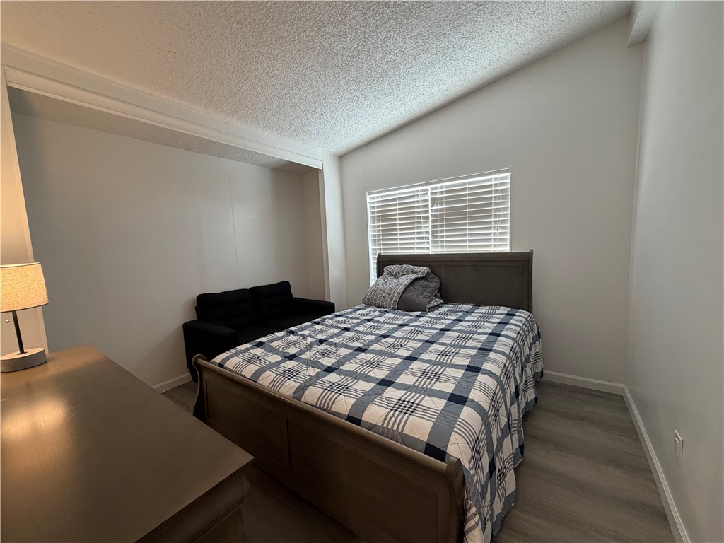 1910 Rio Grande Road Bullhead City, AZ 86442 - Photo 22 of 29 Room featuring an angled ceiling, light gray walls, and wood-finish flooring