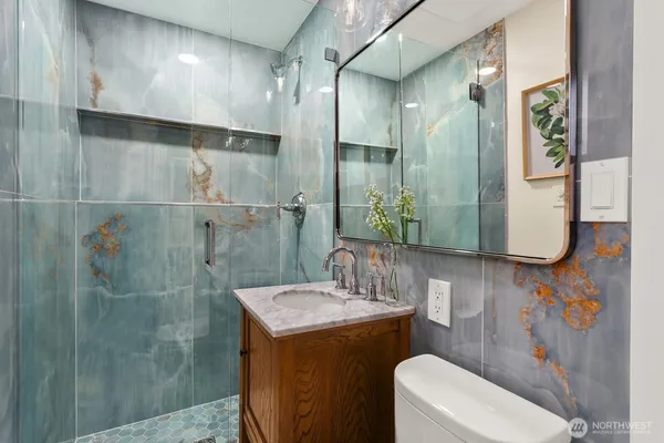 a bathroom with a granite countertop sink a toilet and shower